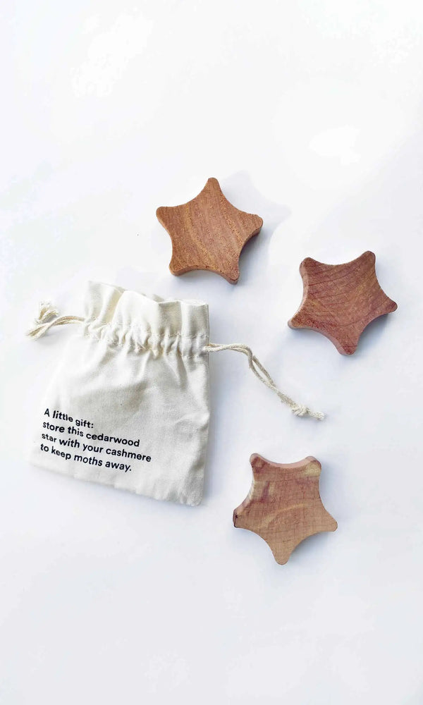 Wooden star-shaped items with a drawstring bag on a white background