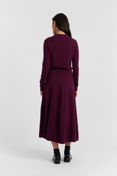 Woman wearing a long burgundy dress on a white background