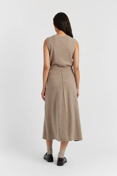 Woman wearing a beige sleeveless dress on a white background