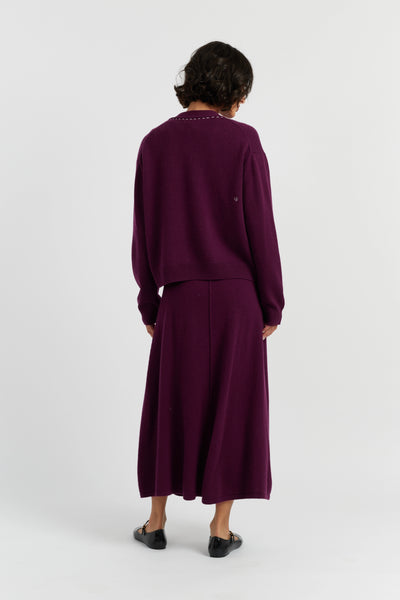 Person wearing a purple outfit on a white background