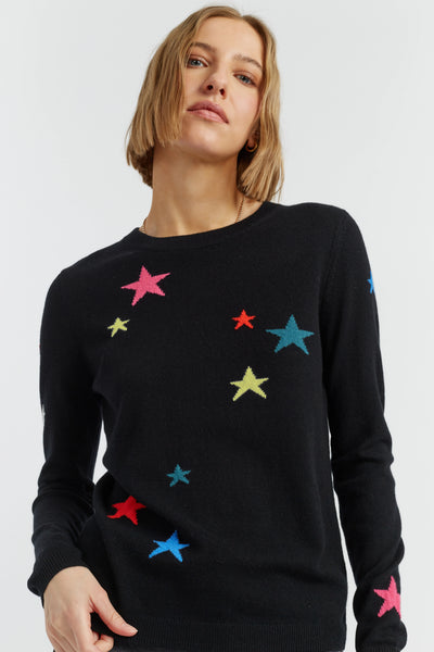 Woman wearing a black sweater with colorful star patterns on a white background