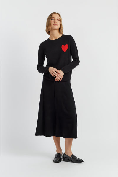 Woman wearing a black dress with a red heart design on a white background