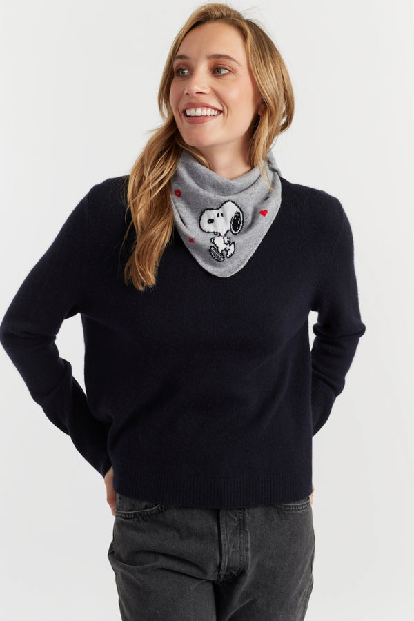 Woman wearing a black sweater and gray scarf with a dog design on a white background