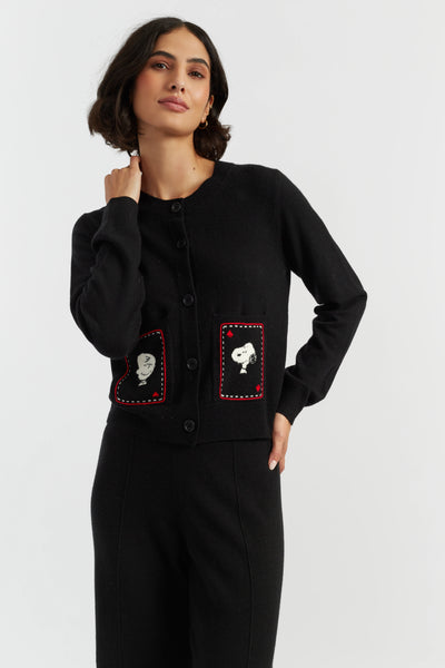Woman wearing a black cardigan with red accents and white designs on a white background