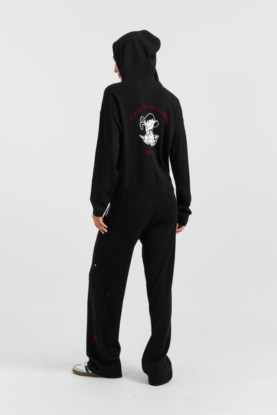Person wearing a black onesie with a graphic design on the back against a white background