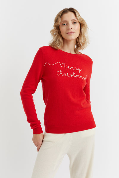 Woman wearing a red 'Merry Christmas' sweater on a white background