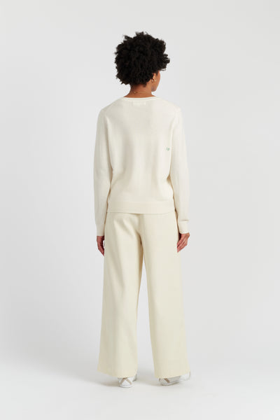 Person wearing a cream-colored outfit on a white background