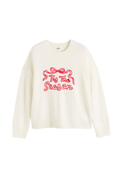 White sweater with red text 'Tis The Season' on a white background