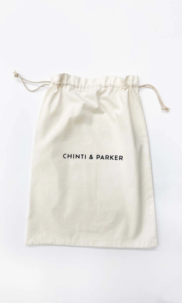 Beige drawstring bag with 'Chinti & Parker' branding on a white background