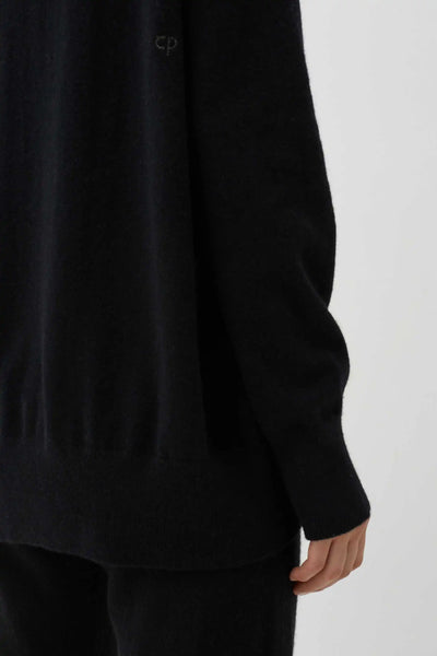 Black long-sleeve shirt worn by a person on a white background