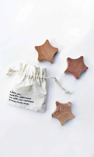 Wooden star-shaped items with a drawstring bag on a white background