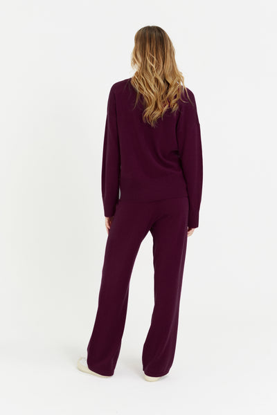 Person wearing a burgundy outfit on a white background