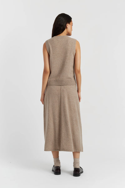 Woman wearing a beige sleeveless dress on a white background