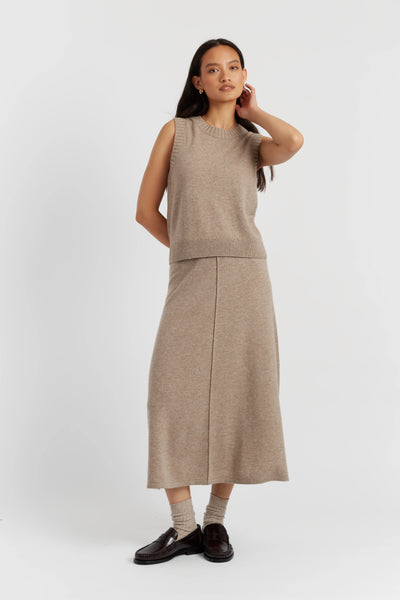 Woman wearing a beige sleeveless top and skirt set on a white background
