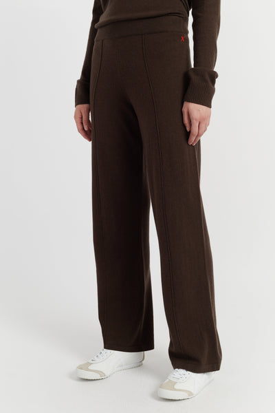 Person wearing brown pants and a dark shirt on a white background