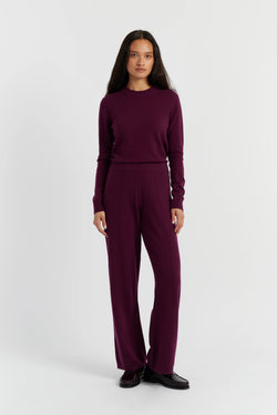 Woman wearing a burgundy outfit on a white background