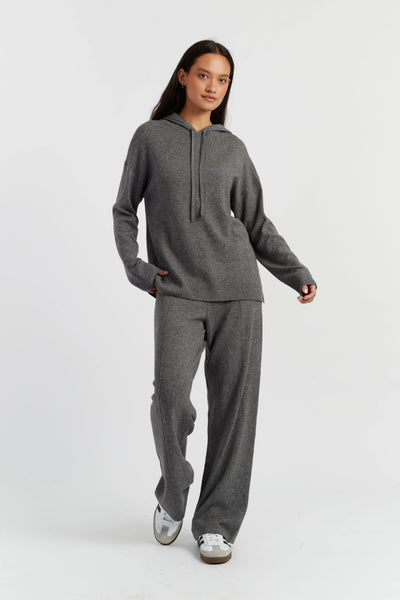 Person wearing a gray hoodie and pants on a white background