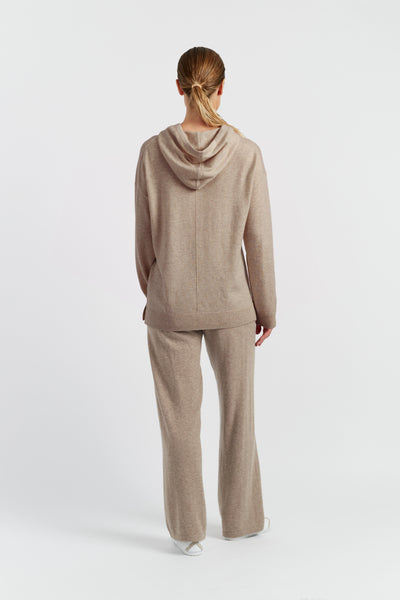 Woman wearing a beige hoodie on a white background