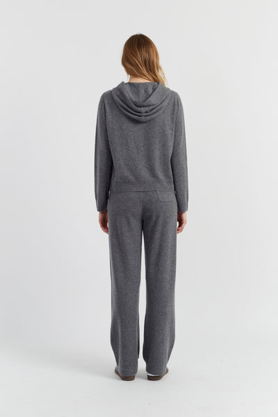 Person wearing a gray hoodie and pants set on a white background