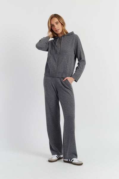 Woman wearing a gray tracksuit on a white background