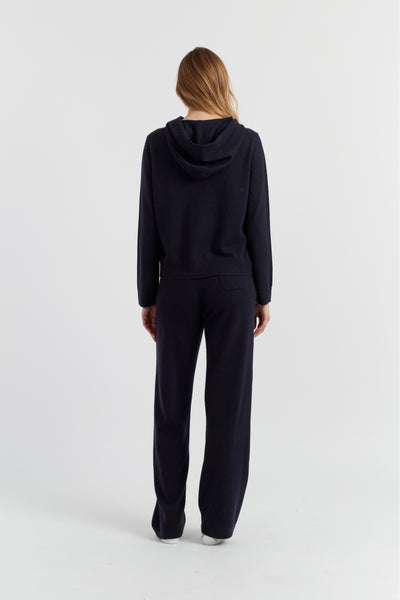 Person wearing a navy blue hoodie and pants on a white background