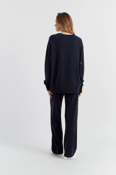 Woman wearing a navy blue outfit on a white background