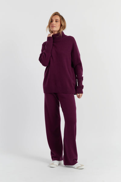 Woman wearing a purple tracksuit on a white background