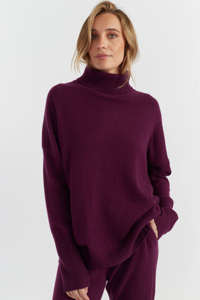 Woman wearing a purple turtleneck sweater on a white background