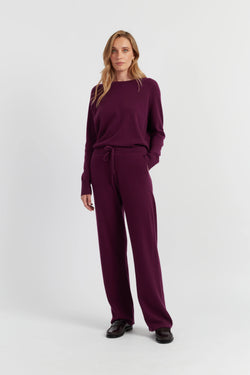 Woman wearing a burgundy outfit on a white background