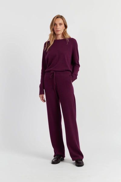 Woman wearing a burgundy outfit on a white background