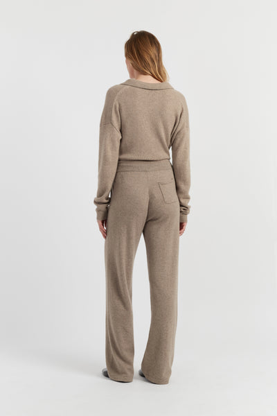 Woman wearing a beige sweater and pants set on a white background