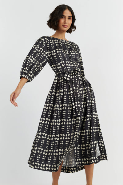 Woman wearing a black and white patterned dress on a light gray background