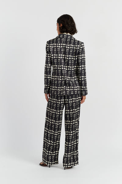 Person wearing a black and white patterned suit on a white background