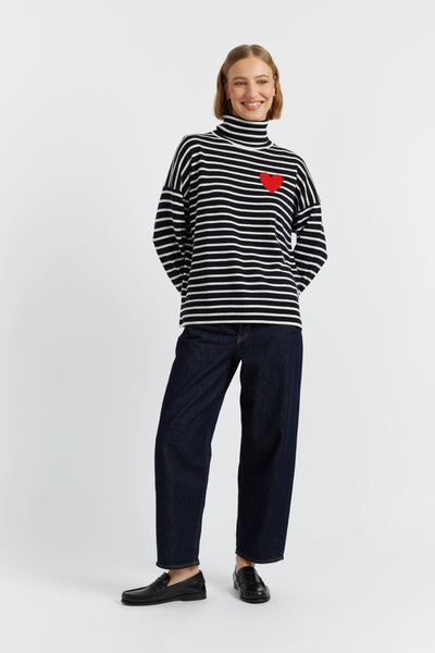 Person wearing a black and white striped sweater with a red heart on a white background
