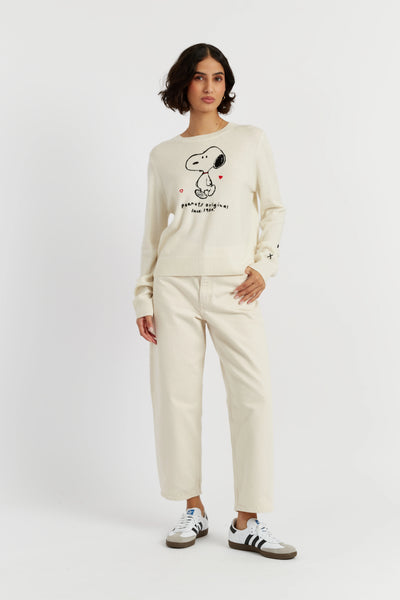 Person wearing a cream-colored sweatshirt with a graphic design on a white background