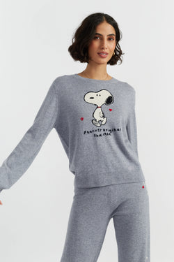 Woman wearing a gray sweatshirt with a Snoopy design on a light gray background