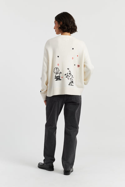 Person wearing a white sweater with black graphics on a white background