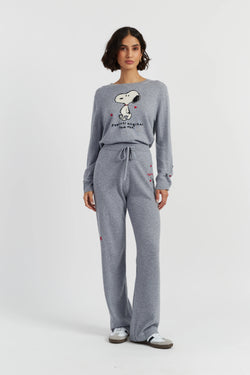 Woman wearing a gray sweatshirt and pants set with a design on a white background