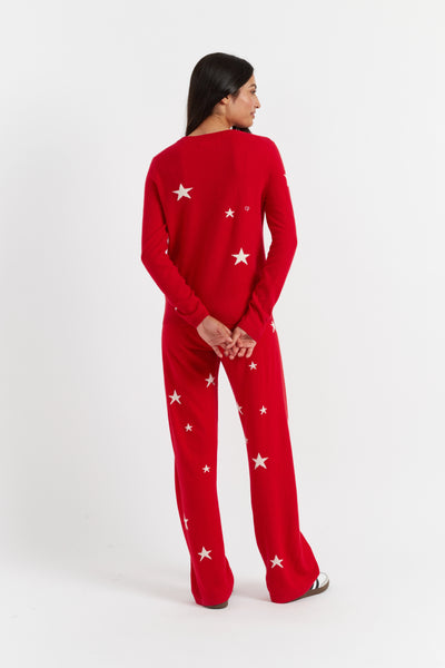 Person wearing a red pajama set with white star patterns on a white background