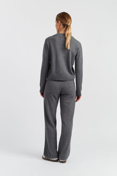 Person wearing a gray sweater and pants set on a white background