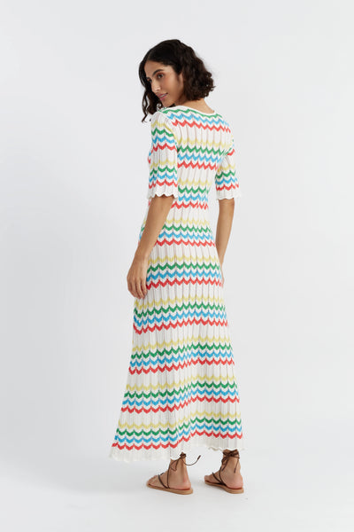 Woman wearing a colorful striped dress on a white background