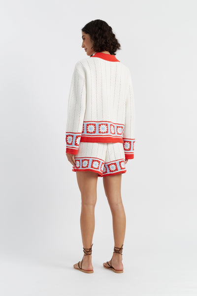 Woman wearing a white and red patterned dress on a white background