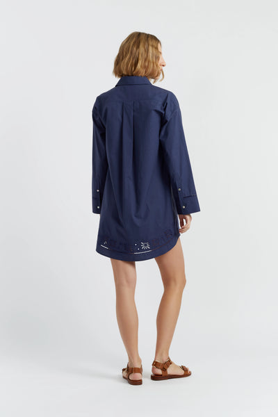 Woman wearing a navy blue dress with a white background