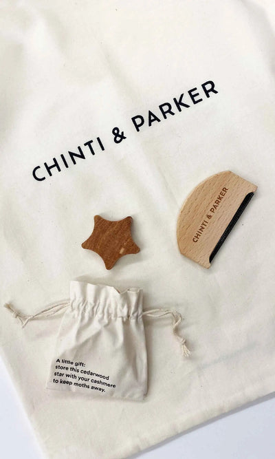 Chinti & Parker wooden star and circle toys on a branded drawstring bag.