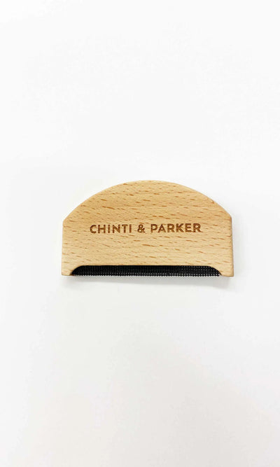 Wooden comb with 'Chinti & Parker' branding on a white background