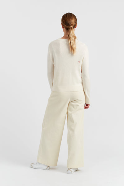 Person wearing a cream-colored outfit on a white background