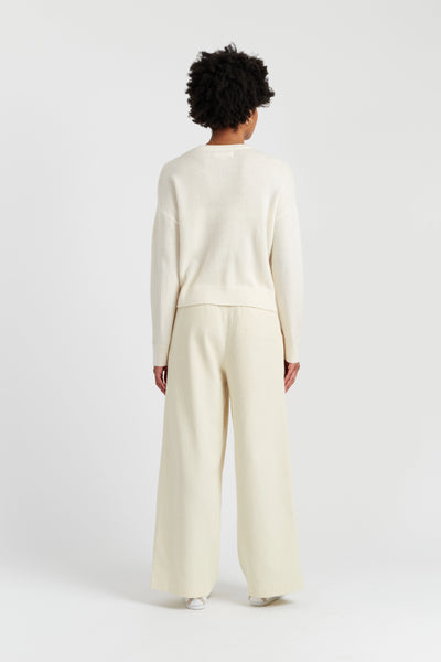 Person wearing a cream-colored outfit on a white background
