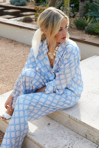 Woman wearing a blue patterned pajama set on a white background