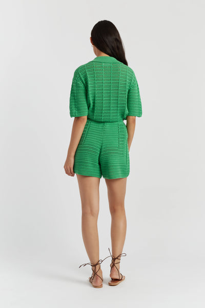 Woman wearing a green patterned romper on a white background