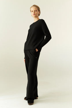 Person wearing a black outfit on a white background